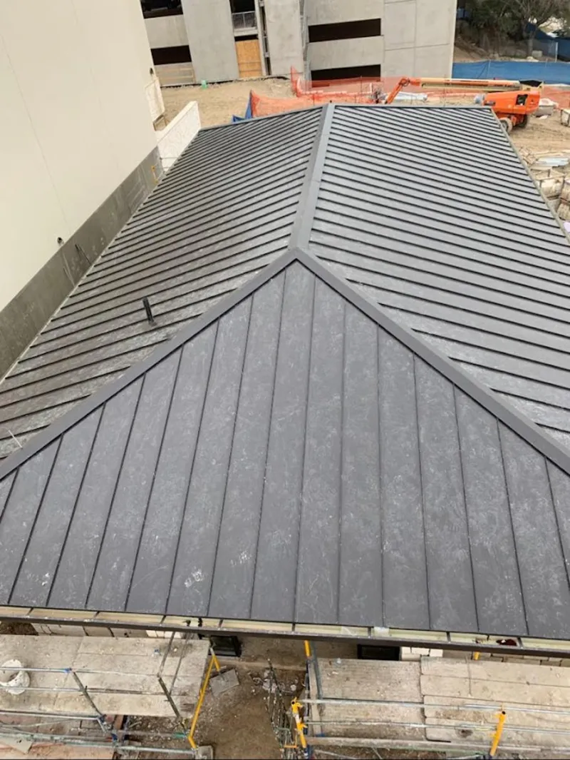 Commercial metal roof construction with crane equipment in Bristol